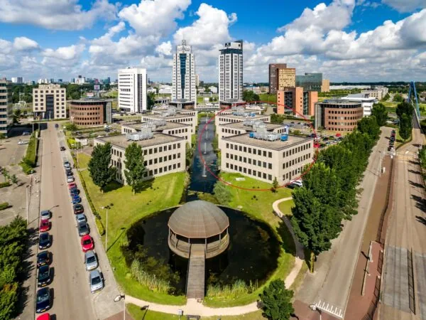 Luchtfoto van kantoorgebouwen aan de Rivium Westlaan in Capelle aan den IJssel, met een ronde vijver en wandelpad op de voorgrond.